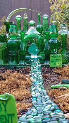 a garden filled with green glass bottles and plants