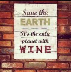 a sign on a brick wall that says save the earth it's the only planet with wine