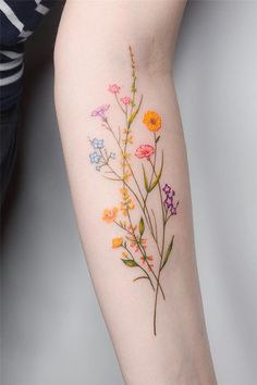 a woman's arm with flowers painted on it