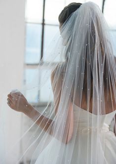 a woman in a wedding dress with a veil on her head