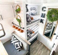 the interior of an rv with wood flooring and white walls, mirrors on the wall