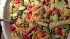 a bowl filled with pasta and vegetables on top of a table