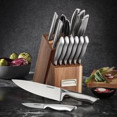 a knife holder with knives and other kitchen utensils on a marble countertop