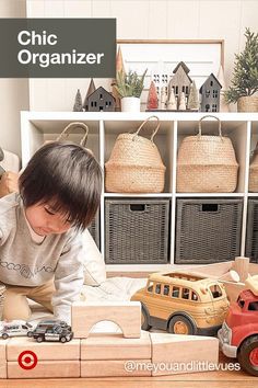 a young boy playing with toys in his living room on a toy train set that is made out of wood