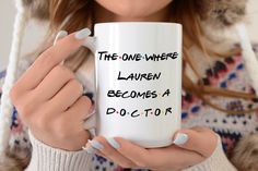 a woman holding a coffee mug with the words, the one where lauren becomes a doctor