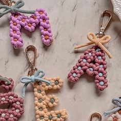 four crocheted keychains sitting on top of a marble counter next to each other