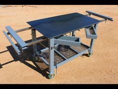 a metal table sitting on top of a dirt field