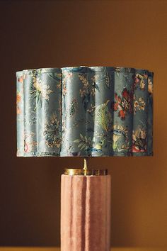 a table lamp that is sitting on top of a wooden table next to a wall