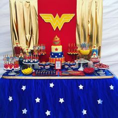 a table topped with cake and desserts on top of a blue cloth covered table