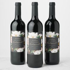 three bottles of wine with labels on them sitting next to each other, one is filled with leaves and the other two are empty