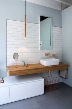 a bathroom with a sink, mirror and bench in it's corner area on the wall