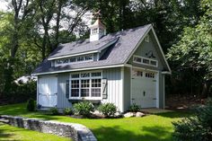 a small house in the middle of some trees and grass with a walkway leading up to it