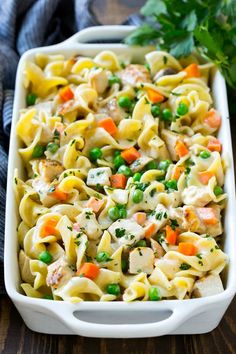 a casserole dish with peas, carrots and chicken