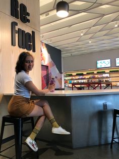 a woman sitting on a stool in front of a counter