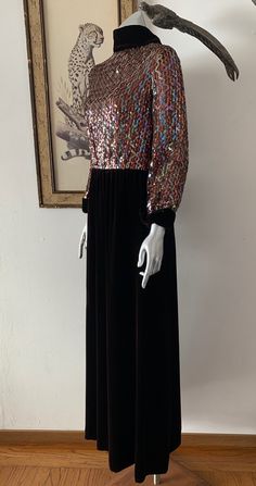 "Amazing 1970s red carpet gown! The sparkly, sequined bodice in the centerpiece to a classic brown velvet rolled high collar, long cuffed sleeve, and straight maxi skirt. Iridescent sequins sewn in vertical wavy design on bodice. High rolled collar with points down the back. Cuffs mirror the collar design. Velvet spine detail with back zip. Hook/eye closures at back neck. Snap closures on cuffs. Bodice is lined with netting. Skirt is lined with with satin. Labelled vintage size 8, but please com Straight Maxi Skirt, Neck Snap, Wavy Design, Rolled Collar, Red Carpet Gowns, Cuffed Sleeve, Classic Brown, Brown Velvet, 1940s Fashion