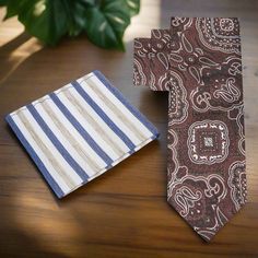 This silk necktie, featuring shades of brown with a detailed paisley pattern, is a refined and versatile accessory that adds a touch of classic charm to any ensemble. The intricate paisley design, rich in texture and depth, showcases a blend of tradition and elegance, making it a standout piece in both professional and social settings. Dress Shirts: Cream Dress Shirt: A cream-colored shirt complements the warm tones of the brown paisley tie, creating a harmonious and sophisticated look. This pai Elegant Brown Suit And Tie Accessories With Pocket Square, Classic Brown Pocket Square For Formal Occasions, Dapper Brown Tie For Business, Elegant Brown Pocket Square For Business, Brown Suit And Tie Accessories With Pocket Square, Classic Brown Neckwear For Formal Occasions, Dapper Brown Suit And Tie Accessories For Semi-formal Occasions, Brown Semi-formal Standard Tie, Elegant Brown Tie