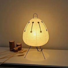 a white lamp sitting on top of a table next to some sticks and other items