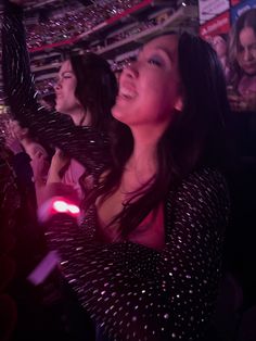 a group of women standing next to each other in front of a crowd at a concert