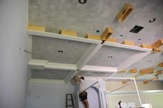 a man is working on the ceiling in a room that has been painted white and gray