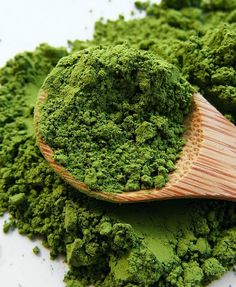 a wooden spoon filled with green powder