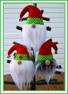 three christmas gnomes are sitting on top of each other