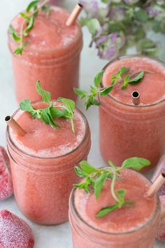 three glasses filled with watermelon and garnished with green leaves