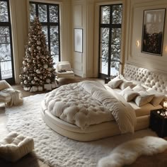 a bedroom decorated for christmas with a large bed in the middle and a lit tree