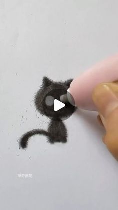 someone is drawing a black cat with a marker