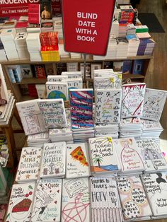 many books are stacked on top of each other in front of a sign that says blind date with a book