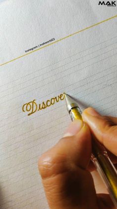 a person writing on a piece of paper with a fountain pen in their left hand