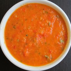 a white bowl filled with tomato soup on top of a table