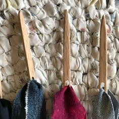 three ties hanging from wooden clothes pins on a bed with white and blue blankets in the background