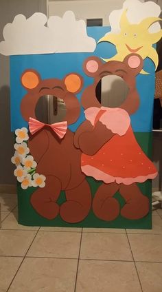 a cardboard bear and girl standing next to each other in front of a mirror with flowers on it