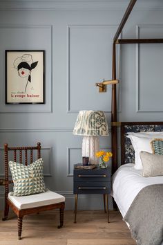 a bed room with a neatly made bed next to a night stand and two lamps