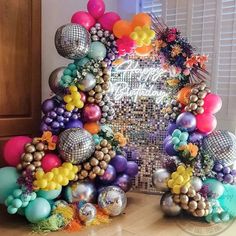 a bunch of balloons that are in front of a mirror on a table with other decorations