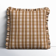 a brown and white checkered pillow sitting on top of a table