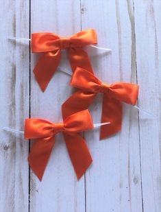 two orange bows are tied on top of each other with toothpicks in the middle