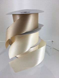 three rolls of white satin ribbons stacked on top of each other