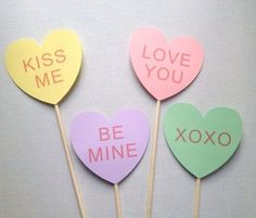 three heart shaped lollipops with the words kiss me, love you and be mine written on them