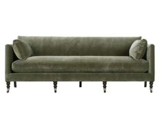 a green velvet couch with two pillows on it's arms and legs, against a white background