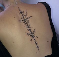 the back of a woman's shoulder with barbed wire tattoos on her upper arm