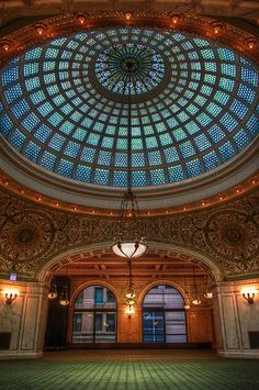 the inside of a large building with a glass dome ceiling and chandelier above it