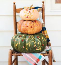 a stack of pumpkins sitting on top of a wooden chair