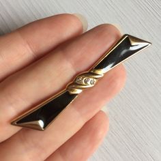 Black enamel bow brooch. Vintage costume jewelry. Good as a scarf, shawl, lapel, or collar pin for women.  ✔ Gold-tone metal. Black enamel. Clear rhinestones  ✔ Size: 6*1 cm, 2 1/4 x 1/2 inch ✔ Condition: very good vintage ✔ Mark: not signed ✔ C clasp ✔ Gift wrapping See more vintage brooches https://www.etsy.com/shop/OldJewelBox?ref=seller-platform-mcnav&section_id=24707449 Chic Black Brooch As A Gift, Chic Black Brooch For Gift, Elegant Formal Enamel Pin Brooch, Chic Black Brooches For Gifts, Elegant Enamel Brooch Pin, Black Brooch With Decorative Bow Gift, Antique Black Brooch For Gift, Vintage Black Brooch Lapel Pin, Cute Enamel Pins