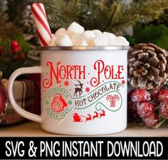 a christmas mug with marshmallows and candy cane in it sitting on a tree stump