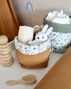 a basket filled with lots of baby items next to a wooden brush and toothbrush