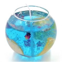 a glass bowl filled with blue liquid and goldfish in it's bottom water