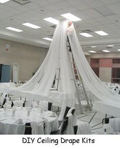 a room filled with tables covered in white table cloths and draping over them