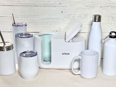 the toothbrush holder is next to several cups and containers, including one with an electric toothbrush