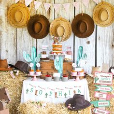 a table with hats and desserts on top of it in front of a wooden wall